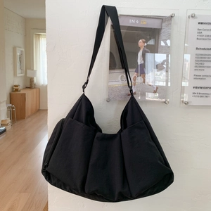 Detailansicht der großen schwarzen Umhängetasche mit mehreren Taschen und Canvas-Textur
