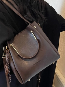 Deep brown crossbody bag with gold metal handles for elegant summer fashion looks