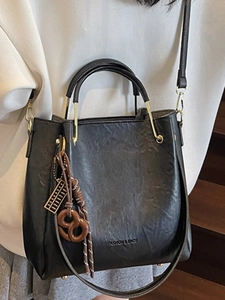 Fashionable black faux leather bucket bag with golden metal handle and shoulder strap