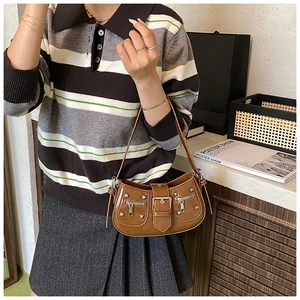Close-up of a brown vintage stud rivet shoulder bag with silver buckles and zippers