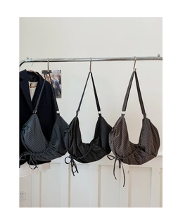 Détail des sacs à cordon à carreaux en toile de couleurs gris, noir et marron