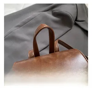 Close-up of retro brown leather handbag handle with fine stitching and embossed details