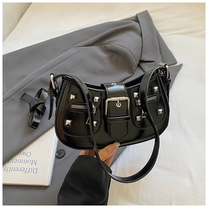Detail of black patent leather underarm bag with silver rivets and buckle straps