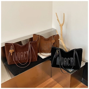 Detailed macro view of three oversized tote bags with INACRI stitching and elephant charms