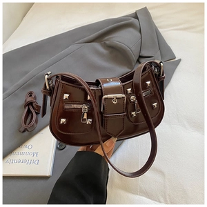 Detail view of brown faux leather handbag featuring silver studs and buckle decoration