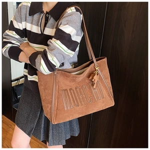 Detail view of brown suede tote bag with MOACHI embroidery and cute animal pendant