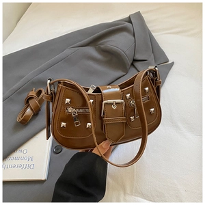 Detail of vintage brown crescent bag with silver rivets and metallic zipper accents