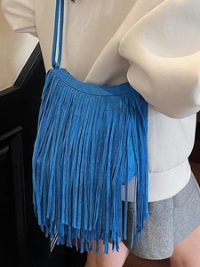 Vibrant bright blue suede fringe shoulder bag with long tassels shown on model