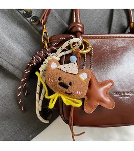Dettaglio del ciondolo a forma di orso con stella in pelle su borsa in pelle cerata