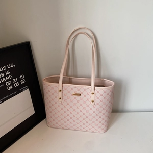 Dettaglio della borsa tote rosa chiaro con motivo a rombi e placca in metallo dorato