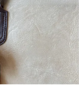 Gros plan sur la texture du cuir PU beige et le logo ZSKE embossé sur le sac cabas