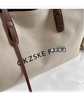 Détail du sac cabas en toile beige avec anses marron et texte imprimé de Paris