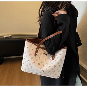 Detail einer großen cremefarbenen Shopper-Tasche mit Rentier-Print und Ledergriffen