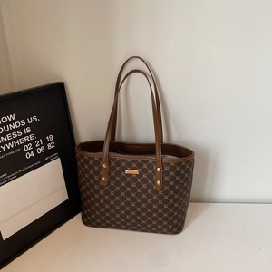 Dettaglio del motivo geometrico e dei componenti dorati sulla borsa tote grande