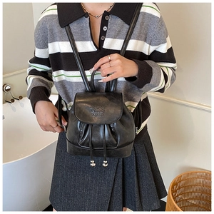 Detail of black mini PU leather backpack with drawstring closure and letter embossing