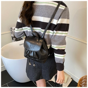Detail of a chic black PU leather mini backpack with drawstring and letter print design