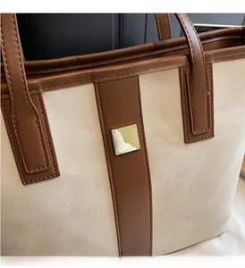 Détail du sac fourre-tout crème et marron avec boucle en métal doré et coutures fines