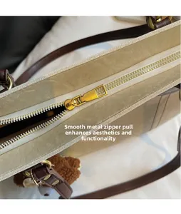 Gros plan du curseur de fermeture éclair en métal sur un sac à bandoulière en similicuir