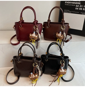 Dettaglio di borse vintage in pelle cerata in quattro colori con ciondoli orsetto
