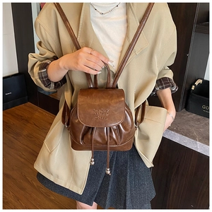 Brown leather mini backpack styled on a model with beige blazer for a chic casual look