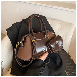 Detail of dark brown leather Boston bag with mini pouch and contrast white stitching