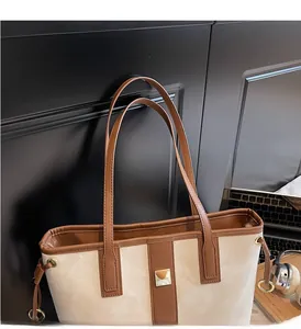 Détail macro du sac fourre-tout bicolore avec tissu ivoire et anses en cuir marron