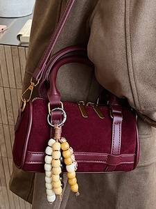 Chic burgundy suede Boston bag with leather trim and beaded tassel for women