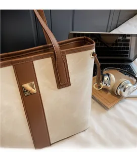 Détails du sac cabas beige montrant la toile de qualité et la poignée en cuir marron