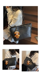 Détail du sac cabas en cuir PU noir avec pendentif ours brun sur des marches en bois