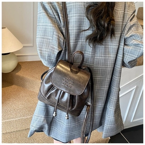 Detail of vintage dark brown PU leather mini backpack with drawstring and flap closure