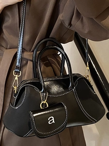 Minimalist black leather Boston bag with white stitching and mini coin purse accessory