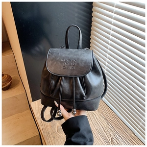 Detail of charcoal black PU leather backpack with vintage texture and embossed letters