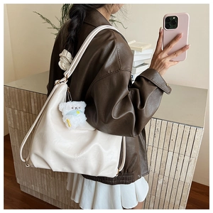 Détail du grand sac cabas en cuir souple blanc cassé avec accessoire de charme ours en peluche