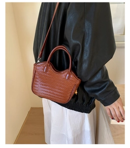 Sac seau tressé marron porté avec texture détaillée et bandoulière réglable