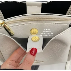 Detail of off-white lychee leather bag with strong magnetic closure and gold hardware