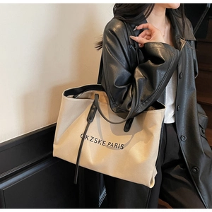 Vue détaillée d'un grand sac cabas en toile beige avec anses noires pour le quotidien
