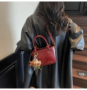 Dettaglio borsa a tracolla retrò in pelle cerata bordeaux con manici a nodo eleganti