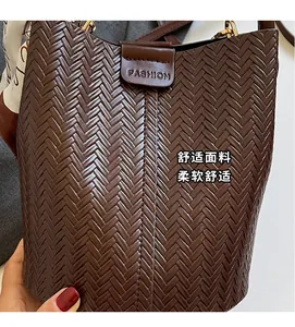 Détail du sac seau tressé marron foncé avec boucle tendance et foulard en soie décoratif