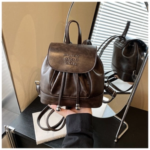 Detail view of coffee brown retro mini backpack with drawstring and flap closure