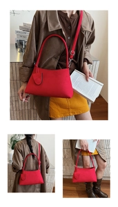 Detailed view of red suede underarm bag with silver hardware and mini coin pouch pendant