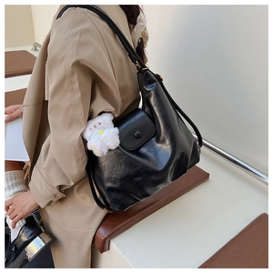 Détail du grand sac cabas noir en cuir PU avec un charmant ours en peluche blanc sur le côté