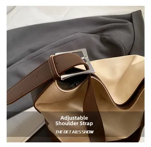 Detailed close-up of the adjustable shoulder strap with silver metal buckle on a tote bag