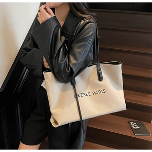 Gros plan détaillé du grand sac cabas en toile avec lanières cuir sur un escalier