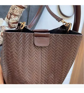 Détail du sac seau tressé marron café avec foulard en soie et boucles en métal doré