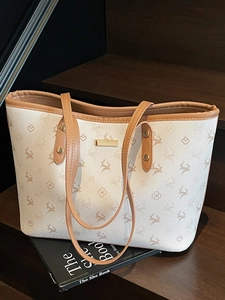 Große beige Leder-Tote-Bag mit Hirschprint und braunen Riemen auf Holztreppe