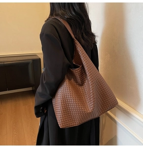 Gros plan sur un grand sac hobo tressé marron montrant les détails de la texture