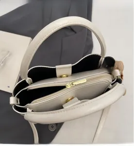 Detail view of white lychee leather bag interior with smooth zipper and golden hardware