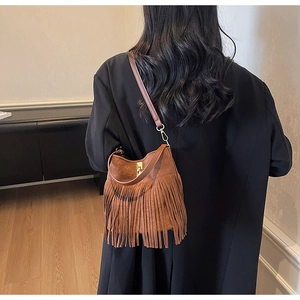 Bohemian brown suede shoulder bag with long fringes and gold twist lock on model back