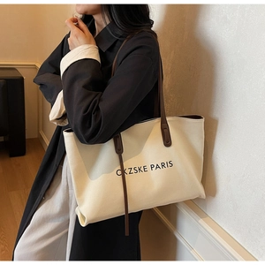 Détail d'un cabas en toile avec poignées en cuir marron et imprimé CKZSKE PARIS