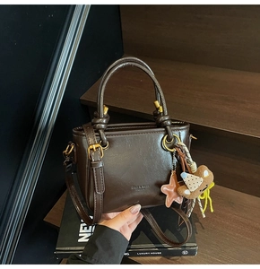 Dettaglio mini borsa tote marrone scuro in pelle cerata vintage con ciondoli carini